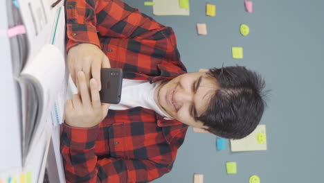 Vertical-video-of-Male-student-chatting-on-the-phone.